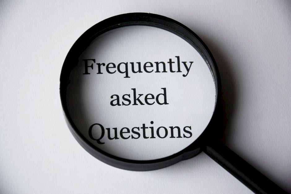 A close-up image of a black-handled magnifying glass with a circular lens, positioned over a plain white surface. Inside the lens, the words 'Frequently asked Questions' are displayed in bold black text, emphasizing the concept of common inquiries. The background around the magnifying glass is clean and simple, with no other objects present. This visual could be associated with informational content or customer support related to home relocation or moving services, reflecting the process of providing clear answers and guidance for clients of Man with Van Beddington during their house removals or furniture transport projects.